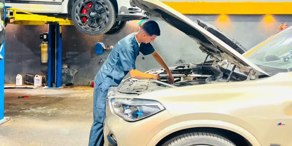 فني في مركز كار إنجين يعمل على محرك سيارة BMW X5